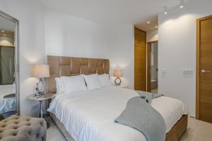ein Schlafzimmer mit einem großen weißen Bett und einem Spiegel in der Unterkunft Luxury 2 bedrooms apartment in Palm-Mar, Tenerife in Palm-mar + 26 Fotos