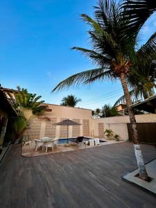 eine Terrasse mit 2 Tischen und einer Palme in der Unterkunft Porto das Dunas Casa Temporada Estilo e Conforto 2 in Aquiraz