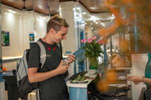 河内Hanoi Solo Hostel的一名男子站在厨房准备食物