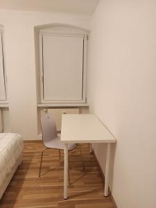 a white table and a chair in a room at Komfortable Wohnung in Kassel +2 photos