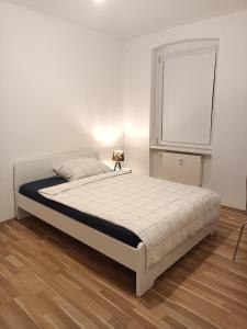 a bed in a white room with a white wall at Komfortable Wohnung in Kassel