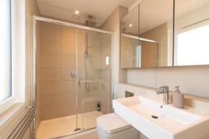 a bathroom with a shower and a sink and a toilet at Modern 5 Bedroom Town House with off St Parking in Bristol