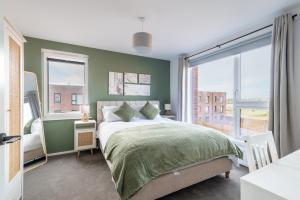 a bedroom with a bed and a large window at Modern 5 Bedroom Town House with off St Parking in Bristol