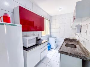 a white kitchen with a sink and a microwave at Apê Elegante I Wi-Fi e A/C in Imperatriz +25 photos