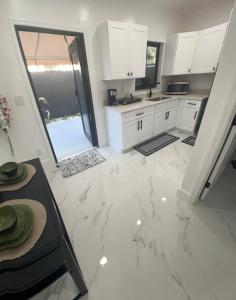 a kitchen with white cabinets and a marble floor at MG Realty in Miami