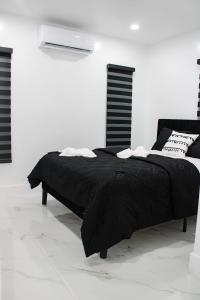 a bed in a white room with a black blanket at MG Realty in Miami