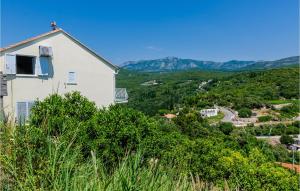 a house on top of a hill with trees at Apartment Gruda With Sea View 02 in Molunat