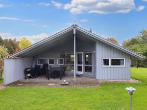 a small grey house with a table and chairs at 4 star holiday home in Nysted in Nysted