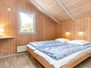 a large bed in a wooden room with a window at 4 star holiday home in Nysted in Nysted