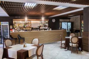 a restaurant with tables and chairs and a bar at Hotel Delta Ognyanovo in Ognyanovo