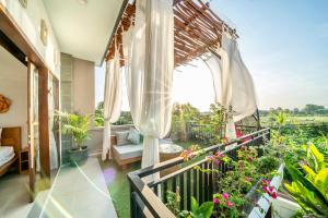 a balcony with a view of a garden at Villa Chelsea in Canggu