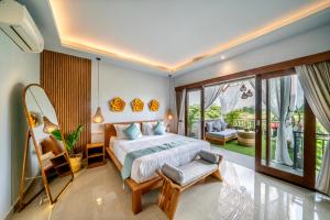 a bedroom with a bed and a balcony at Villa Chelsea in Canggu