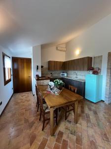 a kitchen with a wooden table and a blue refrigerator at Casa vacanze Pierangela in Susegana +23 photos