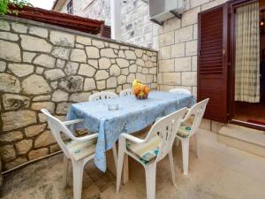 a table with white chairs and a blue table cloth at Apartment Mari in Supetar