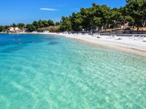 a beach with a bunch of people in the water at Apartment Mari in Supetar