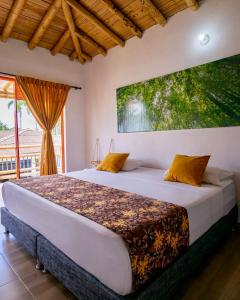 a bedroom with a large bed with a large window at Hotel La Aldea Pijao in Montenegro