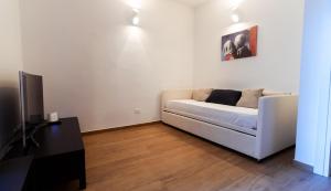 un soggiorno con un divano bianco e una TV di Exclusive apartment - Magritte Style a Lecco