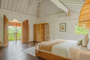 a bedroom with a bed in a room at Villa Umasana Private Balinese House and Garden in Canggu