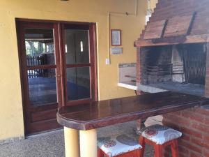 Ein Holztisch mit Hockern vor einem Kamin in der Unterkunft El buen descanso in San Bernardo