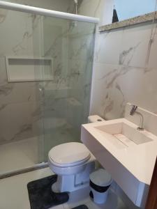 a bathroom with a toilet and a shower and a sink at Pousada Studio Flat Jequié in Jequié