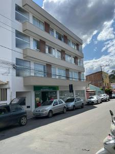 a large building with cars parked in front of it at Pousada Studio Flat Jequié in Jequié