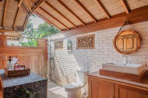 a bathroom with a sink and a toilet at Villa Umasana Private Balinese House and Garden in Canggu