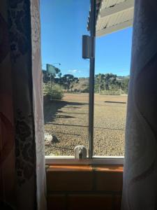 an open window with a view of a field at Pousada Frio da serra in Bom Jardim da Serra