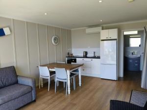 a living room with a table and chairs and a kitchen at Braxmere Lodge in Turangi