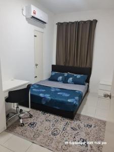 a bed in a room with a desk and a bed sidx sidx sidx at Kamilia Homestay Anderson Ipoh in Ipoh
