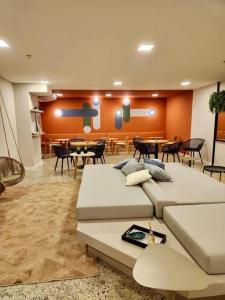 Zimmer mit Sofa, Tischen und Stühlen in der Unterkunft Studio Luxo Piscina e Ar Condicionado in Rio de Janeiro + 55 Fotos