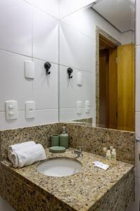 eine Badezimmerablage mit Waschbecken und Spiegel in der Unterkunft Studio Luxo Piscina e Ar Condicionado in Rio de Janeiro