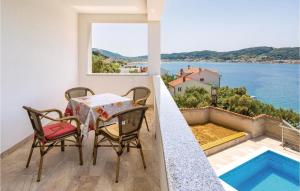 a balcony with a table and chairs and a view of the water at Pet Friendly Home In Supertarska Draga in Supetarska Draga