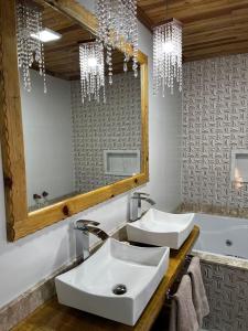 a bathroom with two sinks and a mirror and a tub at Pousada Frio da serra in Bom Jardim da Serra +42 photos