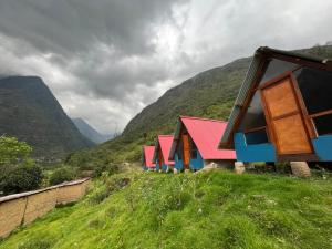 a row of houses on a hill with mountains in the background at Salkantay Lodge Collpapampa in Colcapampa