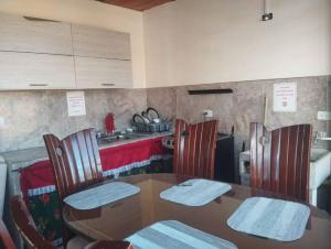 a dining room with a table and chairs and a kitchen at Habitación familiar Maoservi in Soacha +8 photos