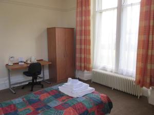 a bedroom with a bed and a desk and window at University Hall - Campus Accommodation in St Andrews