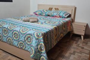 a bed with a colorful blanket and pillows on it at Espacioso y lindo lugar in Bello