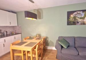 una cucina e una sala da pranzo con un tavolo e un divano di Wald Apartments im Predigtstuhl Resort a Sankt Englmar