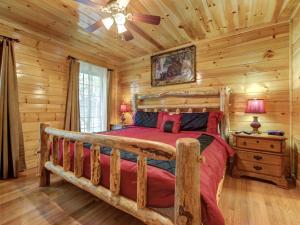 Un dormitorio con una cama en una cabaña de troncos en Smokies Bungalow chalet, en Gatlinburg