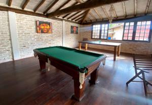 a room with a pool table and two tables at Patio Camburi - Flat com Piscina à 60m da Praia de Camburi in São Sebastião