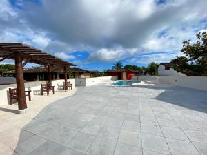 a patio with a picnic table and a pavilion at Patio Camburi - Flat com Piscina à 60m da Praia de Camburi in São Sebastião