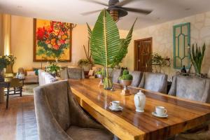 Luxury Villa in Cozumel with Pool & Hot Tub في كوزوميل: غرفة طعام مع طاولة وكراسي خشبية