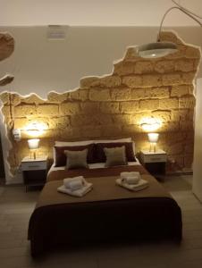 a bedroom with a large bed with two towels on it at ChiaraValle Apartment Agrigento in Agrigento