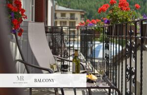 
a bird sitting on top of a wooden bench at Monte Rosa Boutique Hotel in Zermatt
