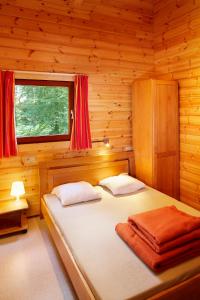 a bedroom with a bed in a wooden cabin at Gite De Boshut in Oignies-en-Thierache