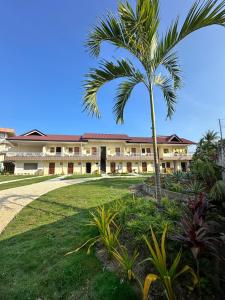 a palm tree in front of a building at On Board Lifestyle Resort FREE MOTORBIKE in Bil-isan