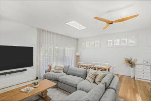 a living room with a couch and a flat screen tv at Lakeshore Serenity @ Warners Bay in Warners Bay