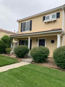 a house with bushes in front of it at Charming 3 bed 3 bath home, super cozy, close to DIA in Altura