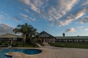 a house with a swimming pool in front of it at Los Naranjos Termal in Termas del Daymán