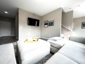 a living room with two couches and a flat screen tv at Central Cedar Falls Townhome - King Beds! in Cedar Falls